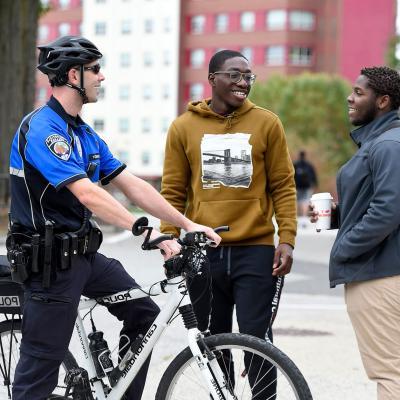 一个骑自行车的警察正在和两个学生讨论